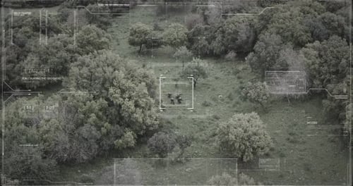 Surveillance drone view of soldiers walking through a forest with hud graphics