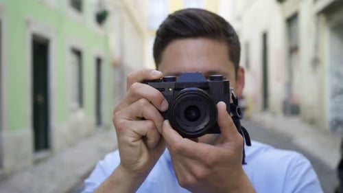 Happy Young Man Taking Pictures in Old City Street