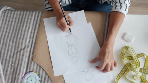 Fashion Designer Sketching Designs on Paper