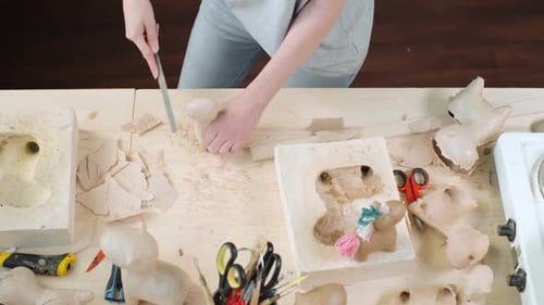 Artist Filing Sculpture in Workshop