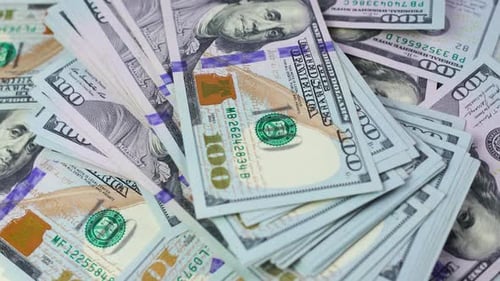 Hundert-Dollar-Scheine fallen in einem Stapel Bargeld auf den Tisch. Geschäfts- und Finanzkonzept.