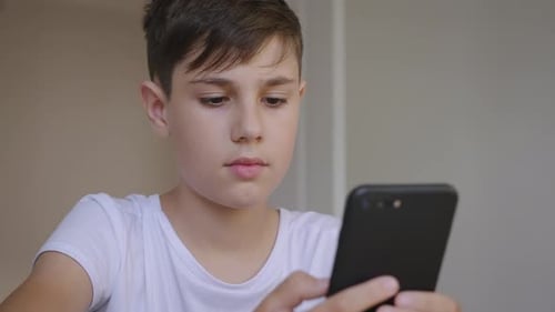 Boy Looking at Cell Phone, Indoor Setting