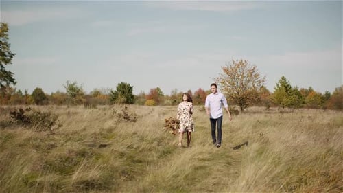 Young Couple in Love Walking on Meadow in Summer - Togetherness Concept.