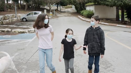 Coronavirus pandemic - kids walking outdoors with face masks to avoid corona