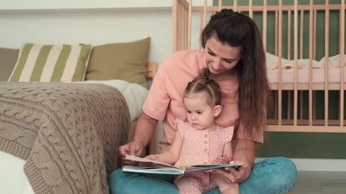 Mother Reading Book with Baby in Bright Room