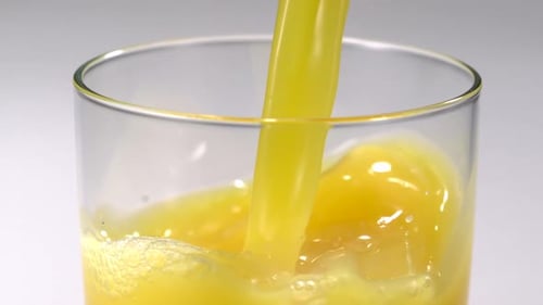 Bright Yellow Juice Pouring into Glass