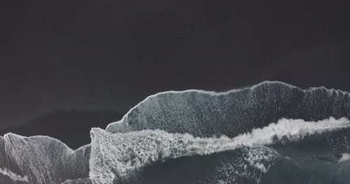 Aerial View. Stunning Aerial Footage of Waves Breaking Against Beautiful Icelandic Black Sand Beach