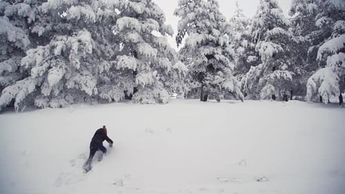 Garçon qui essaie de grimper dans la neige.