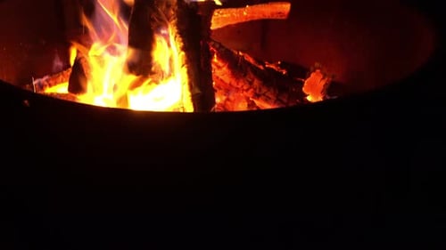 Burning Wood Logs in a Fire Pit at Night