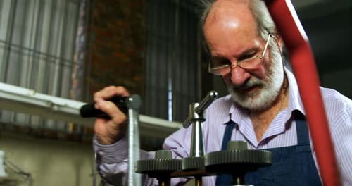 Goldsmith working on machine in workshop