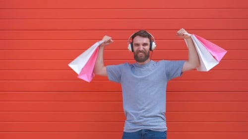 Man Celebrates with Shopping Bags and Headphones