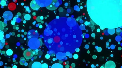 Multicolored confetti or glitter particles glitter in the light with depth of field.