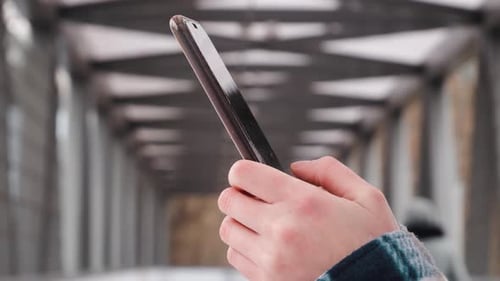 Side view. Hand of girl using smartphone in office, typing message. Close up of young women hand. Be