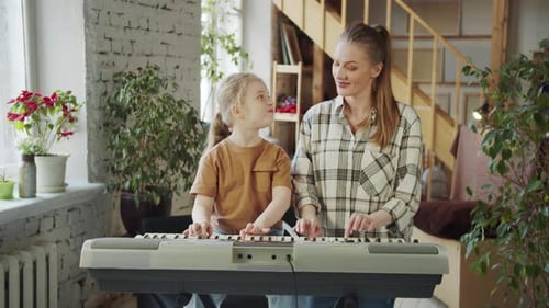 Child and Mother Play Electronic Keyboard at Home