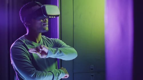 African american male computer technician using vr headset working in business server room