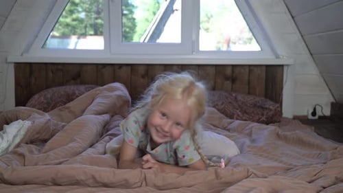 Blonde Girl Smiling on Bed in Cozy Bedroom