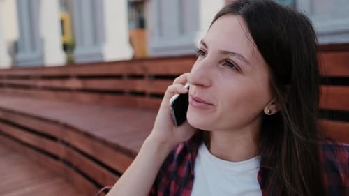 Smiling Woman Talking on the Phone Outside