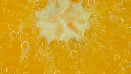 Luftblasen um eine Orangenscheibe.