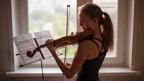 Woman Plays Violin by Window Light