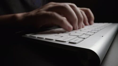 Close-up typing on keyboard with man fingers. Macro soft focus dolly shot.