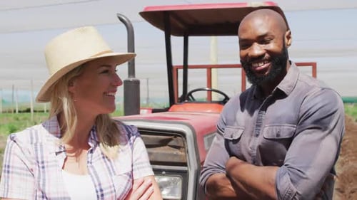 Cheerful Farmers Smiling in Front of Tractor