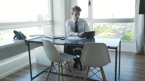 Businessman using digital tablet and laptop in office