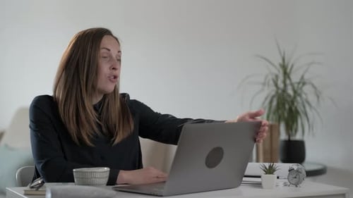 Woman Attending Video Conference at Desk in Home Office
