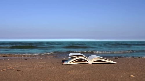 Weiße Buchseiten, die von starkem Wind am gelben Strand gedreht wurden