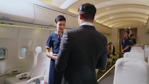Cabin Crew Greeting Passenger in Airplane