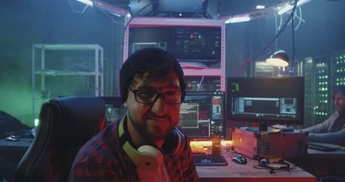Young Adults Working at Computers in Smoky Room