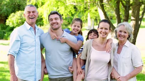 Família estendida rindo da câmera no jardim