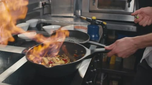 Chef Flambeing Vegetables in a Commercial Kitchen