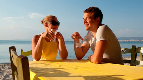 Couple Toasting Drinks Together at a Beach Restaurant