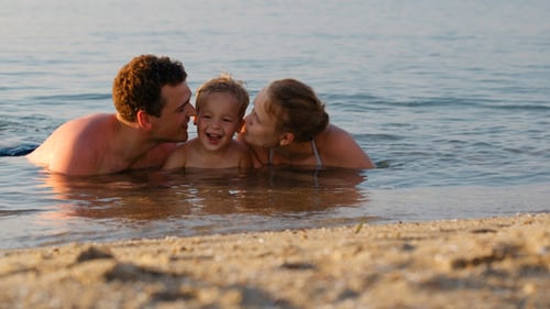 Laughing Little Boy With His Parents At The Sea