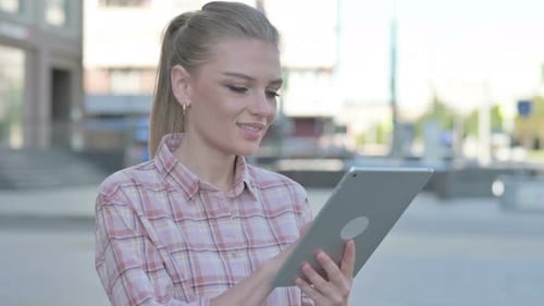 Young Woman Using Tablet Device in City Setting