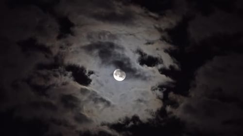 Full Moon Moving Between Clouds