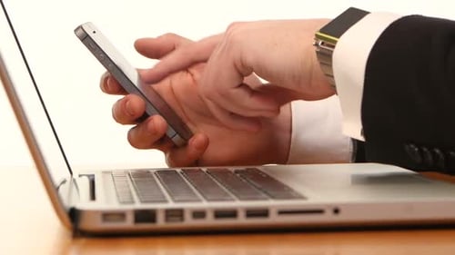 Adult Typing on Laptop and Using Cellphone
