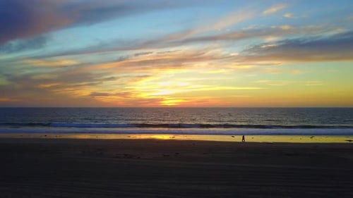Aerial drone view of a sunset at the beach over the ocean.