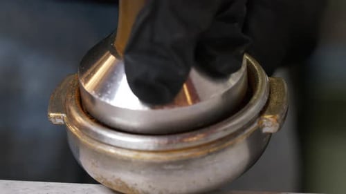 Close Up of Barista Tamping Coffee Grounds