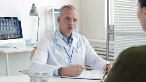 Doctor Consults With Patient in Bright Office