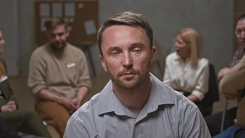 Man Wipes Tears at Group Therapy Session