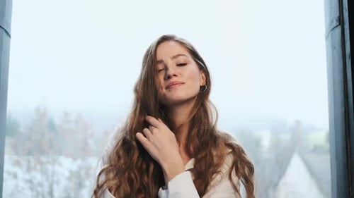 Cheerful Young Girl Playfully Touches Her Hair.