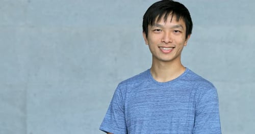 Asian young man smile to camera over grey background