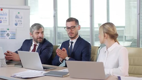 Business People Meeting at Desk Using Laptops