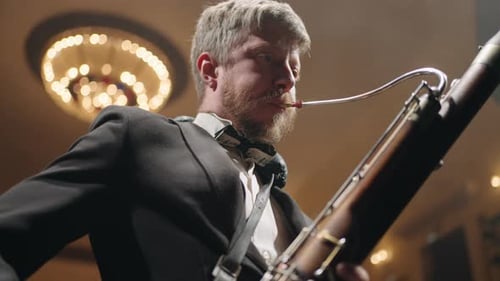 Talented Musician with Traditional Wind Instrument on Scene Man is Playing Bassoon Blowing Air