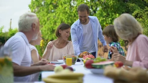 Family Gathering at Picnic Table in Summer Garden