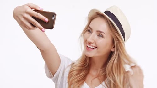 Smiling Woman Taking Playful Selfies with Phone