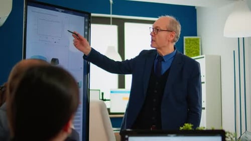 Business Professional Explains Data Presentation to Colleagues