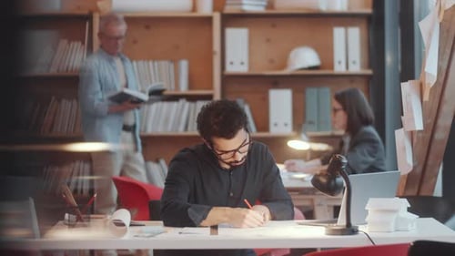 Architect Working on Plans in Airy Office