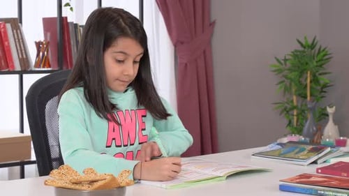 Girl Doing Homework at Table in Bright Room